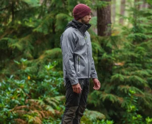 Mann in legerer Arbeitskleidung steht im Wald