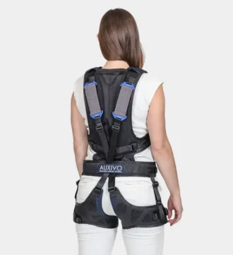Frau mit weisser Kleidung trägt Exoskelett. Ansicht von Hinten